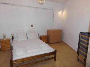 a bedroom with a white bed and a wooden dresser at Giorgio in Kritsa