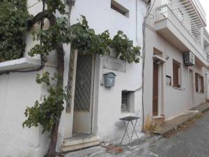 a stool sitting outside of a white building at Giorgio in Kritsa