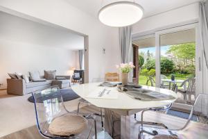 a living room with a white table and chairs at Ferienhaus Auszeit Meer in Cuxhaven