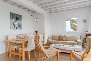 a living room with a table and a couch at Vassilis Family Villa Tinos in Triandáros