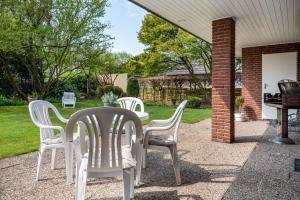 a group of white chairs sitting on a patio at Ferienhaus Auszeit Meer in Cuxhaven