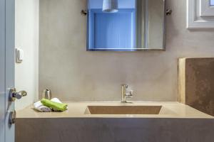 a bathroom with a sink and a mirror at Vassilis Family Villa Tinos in Triandáros +17 photos