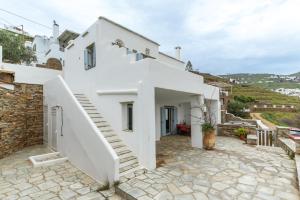 a white villa with a staircase leading up to it at Vassilis Family Villa Tinos in Triandáros