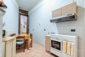 a kitchen with a stove and a dining room at Meraviglie Salentine - Lecce in Lequile +16 photos