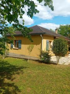 a yellow house with a lawn in front of it at La Bertrandie in Florimont-Gaumiers
