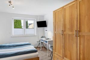 a bedroom with a bed and a desk and a cabinet at Ferienwohnung Eichenauer in Angersbach