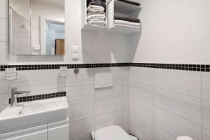 a white bathroom with a sink and a toilet at Ferienwohnung Eichenauer in Angersbach +25 photos