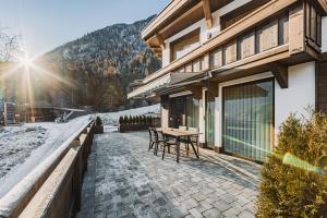 a patio of a house with a table in the snow at See das Ferienhaus in Oetz