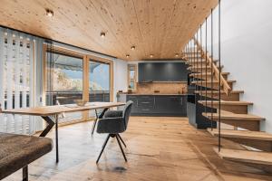 a kitchen and dining room with a table and a staircase at See das Ferienhaus in Oetz