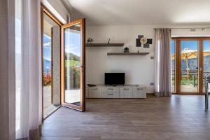 a living room with a television and a mirror at Agriturismo Bocca Nevese Abete in Tremosine Sul Garda