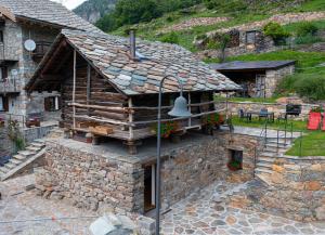 a stone building with a bell on top of it at Casa Girod - Rascard in Issime