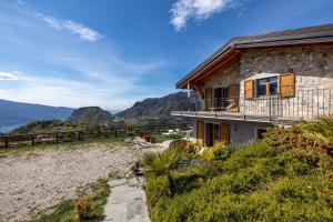 a stone house with a view of the mountains at Agriturismo Bocca Nevese Abete in Tremosine Sul Garda