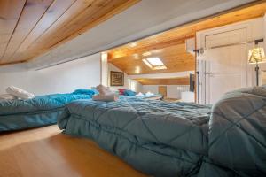 two beds in a room with wood ceilings at Affittacamere Monica in Levanto