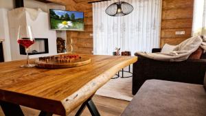 a living room with a wooden table with a glass of wine at Naturstamm Chalets in Untergriesbach