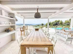 a dining room with a wooden table and chairs at The Privacy Villa by Seaviews in Porto Heli