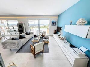 a living room with blue walls and a couch at The Privacy Villa by Seaviews in Porto Heli