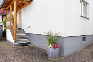 a vase with flowers in it next to a building at Ferienwohnung Eichenauer in Angersbach
