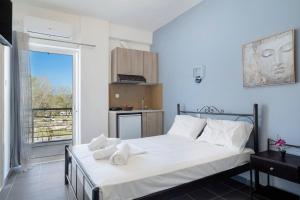 ein Schlafzimmer mit einem Bett mit weißer Bettwäsche und einem Fenster in der Unterkunft Iguana studio 2 in Preveza