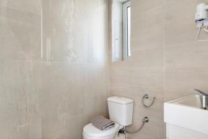 ein Badezimmer mit weißer Toilette und Waschbecken in der Unterkunft Iguana studio 2 in Preveza