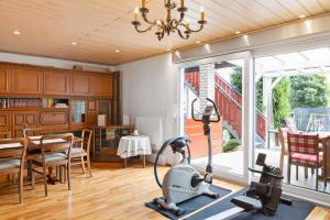 a home gym with a treadmill and a dining room at Ferienwohnung Eichenauer in Angersbach