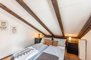 a small attic bedroom with a bed and wooden beams at Ferienhaus Vorauf - Rosenbauer in Siegsdorf