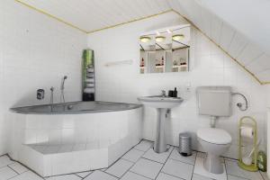 a bathroom with a tub and a toilet and a sink at Haus Kornfeld in Kehl am Rhein +21 photos