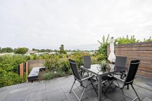 a patio with a table and chairs and a fence at Ferienbungalow Süssau in Süssau