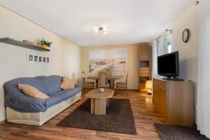 a living room with a blue couch and a tv at Haus Kornfeld in Kehl am Rhein