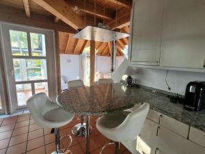 a kitchen with a table and some white chairs at lichtdurchflutetes Architektenhaus in Balingen