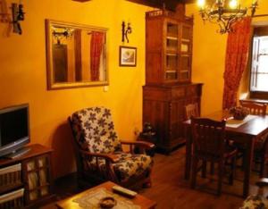 a living room with a chair a desk and a tv at El Jermoso in Posada de Valdeón