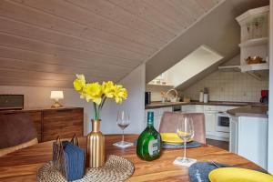 a dining room table with wine glasses and yellow flowers at Angernest in Elfershausen +26 photos