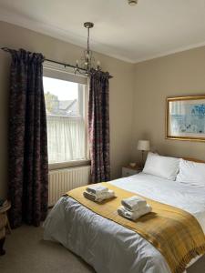 a bedroom with a bed with two towels on it at Gyves House in Eastbourne