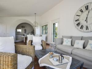 a living room with a large clock on the wall at Li Conchi 13 in Castiadas