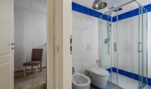 a bathroom with a toilet and a glass shower at Li Conchi 13 in Castiadas +24 photos