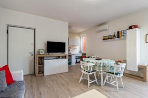 a living room with a table and chairs and a television at My town home apartment in Torri del Benaco +9 photos
