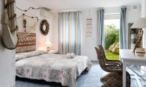 a bedroom with a bed and a table and chairs at Li Conchi 13 in Castiadas