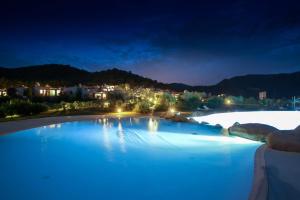 a large pool with blue water at night at Li Conchi 13 in Castiadas