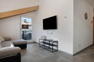 a living room with a couch and a tv on a wall at Cà Dei Nane Vermiglio in Vermiglio