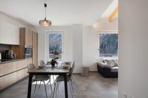a kitchen and living room with a table and a couch at Cà Dei Nane Vermiglio in Vermiglio