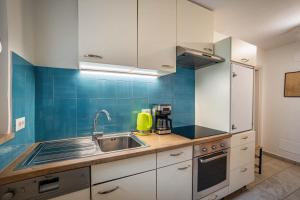 a kitchen with white cabinets and a sink at Silbernagl sonnig mit Gartenblick in Issengo