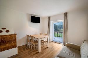 a living room with a table and a couch at Silbernagl sonnig mit Gartenblick in Issengo