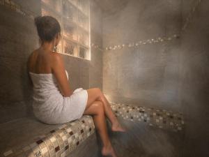 a woman in a white dress sitting in a bath tub at Logis Hôtel Les Grenadines in Cap d'Agde