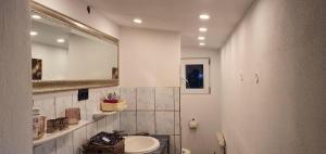 a bathroom with a sink and a mirror at Ferienhaus am Wald in Reichshof  +17 photos