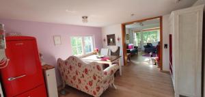 a living room with a red refrigerator and a couch at Ferienhaus am Wald in Reichshof 