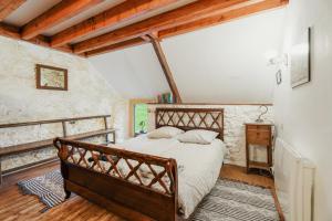 a bedroom with a wooden bed in a room at Maison Plage Verger Cancale in Cancale
