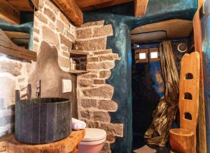 a bathroom with a stone wall and a bath tub at Chalet Armonia Res Albert in San Guglielmo