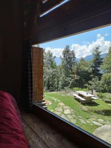 a window in a room with a view of a yard at Chalet Armonia Res Albert in San Guglielmo +3 photos