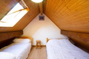 two beds in a attic bedroom with a window at Appartement n°10 - 8 personnes in Saint-Sorlin-dʼArves