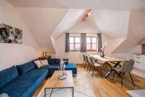 a living room with a blue couch and a table at Ferienwohnung Josef in Gilching