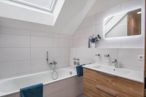 a white bathroom with a tub and a sink at Ferienwohnung Josef in Gilching +14 photos